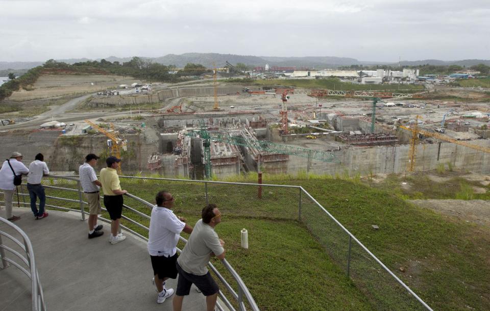 In this Jan. 11, 2014 photo, visitors look at the construction site of the Panama Canal's Atlantic side in Gatun, north of Panama City. A possible stop-and-restart of the canal expansion, one of the largest construction efforts in the world, could mean a delay of months or even years, setting back the arrival of bigger ships, and higher fees, to ports along the entire U.S. East Coast. (AP Photo/Arnulfo Franco)