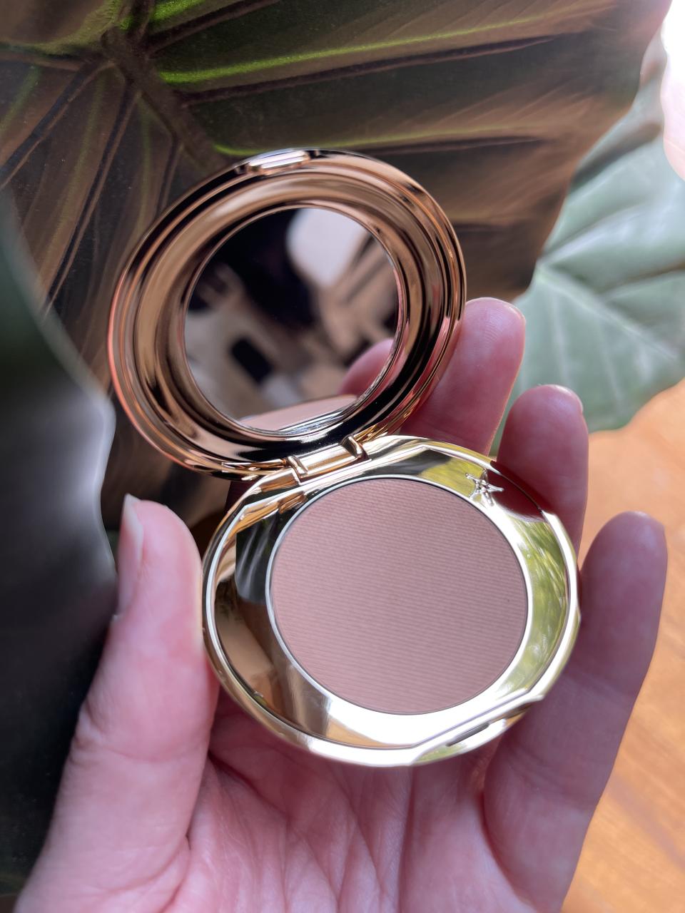 someone holding the charlotte tilbury magic vanish colour corrector