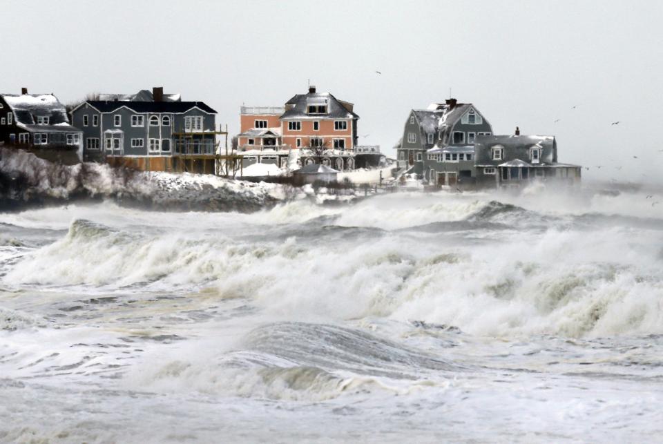 Waves crash on the shore during high tide in Hull, Mass., Friday, Jan. 3, 2014. Wind-whipped, fluffy snow continued to fall across the state, buffeted by wind gusts at around 40 miles per hour. National Weather Service reported Friday morning that the temperature in Boston was 2 degrees, but 20-below when the wind chill is factored in. (AP Photo/Michael Dwyer)