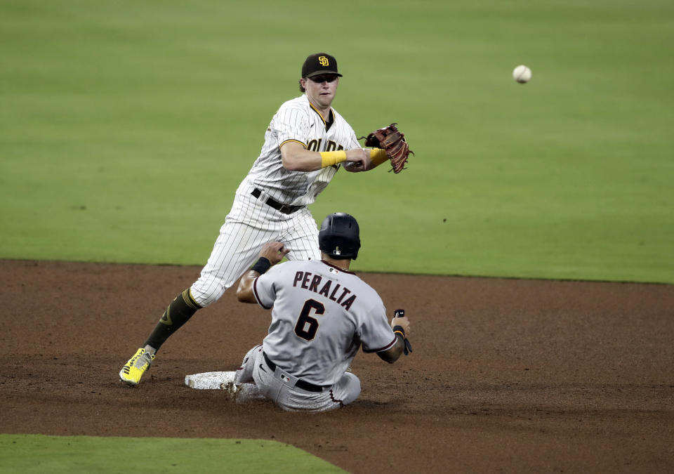 San Diego Padres' Jake Cronenworth, top, turns a double play as Arizona Diamondbacks' David Peralta (6) attempts to break up the play in the sixth inning of a baseball game Saturday, Aug. 8, 2020, in San Diego. Diamondbacks' Eduardo Escobar was out at first base. (AP Photo/Derrick Tuskan)