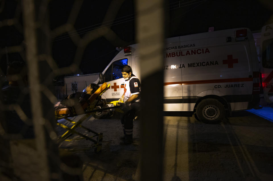 In this July 24, 2019, photo, paramedics carry Yanisley Estrada Guerrero to an ambulance after she complained of tightness in her chest and an accelerated heart rate at El Buen Pastor shelter for migrants in Cuidad Juarez, Mexico. "Everyone cries here, even though we try to keep each others' spirits up," said Guerrero, a 33-year-old Cuban economist and former bank manager. "I still cry almost every day. But I do it in the shower because I don't want anyone to see." (AP Photo/Gregory Bull)