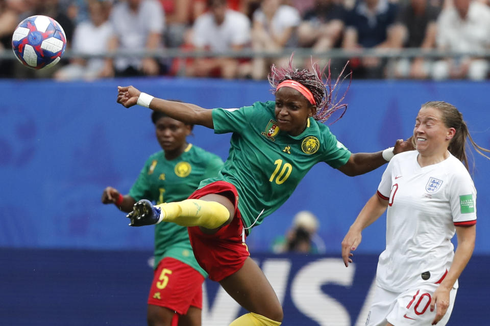 Cameroon's Jeannette Yango, left, reaches for the ball as in action with England's Fran Kirby during the Women's World Cup round of 16 soccer match between England and Cameroon at the Stade du Hainaut stadium in Valenciennes, France, Sunday, June 23, 2019. (AP Photo/Michel Spingler)