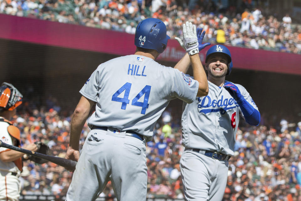 Los Angeles Dodgers Brian Dozier, right, celebrates with Rich Hill (44) after he hit a two-run home run against the San Francisco Giants in the third inning of a baseball game in San Francisco, Sunday, Sept. 30, 2018. (AP Photo/John Hefti)