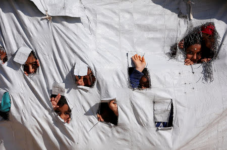 Children look through holes in a tent at al-Hol displacement camp in Hasaka governorate, Syria April 2, 2019. REUTERS/Ali Hashisho/Files