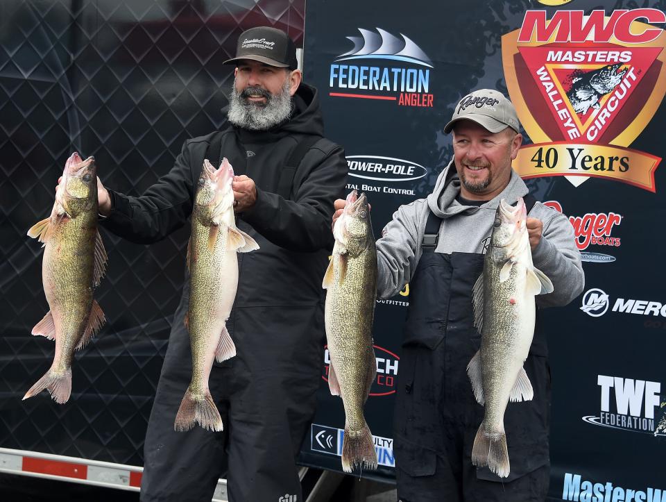 Erick Schenavar of Newport (left) and Michael Sitko of Pinckney hold up 4 of the 5 walleye they caught on Lake Erie Saturday to give them a total weight of 61.1 pounds to win a Masters Walleye Circuit tournament in Monroe.