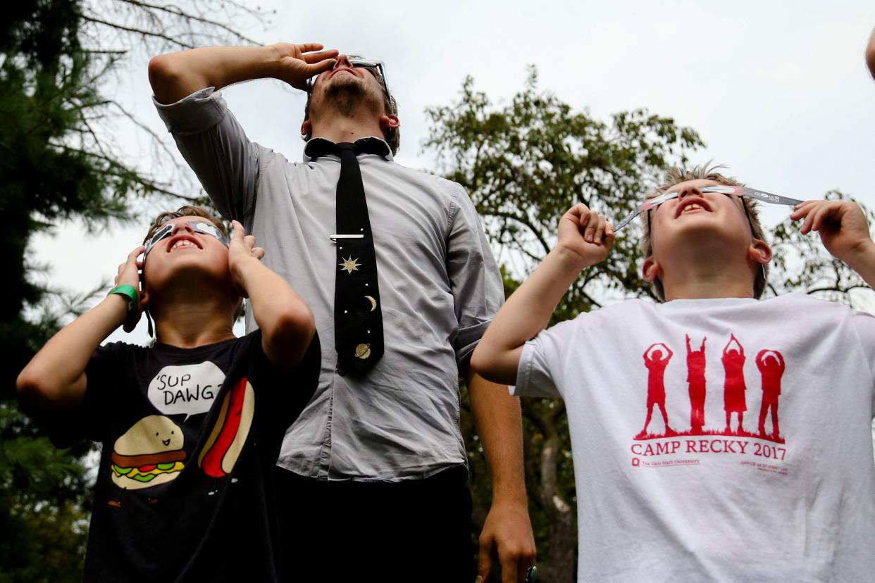 A teacher and students watch the solar eclipse in 2017 at the Columbus Metropolitan Library Whetstone Branch. Ohio will be home to a much larger eclipse event on April 8.