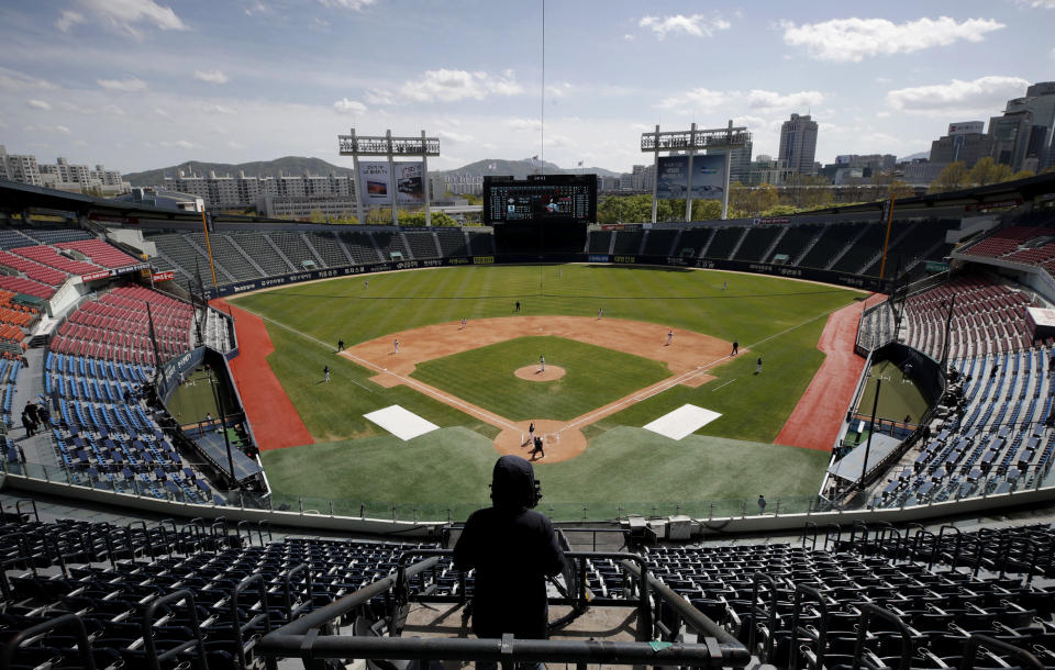 Image: A cameraman films a pre-season baseball game between the Doosan Bears and LG Twins in Seoul on April 21, 2020. South Korea's baseball season will begin on May 5 without fans. (Lee Jin-man / AP file)