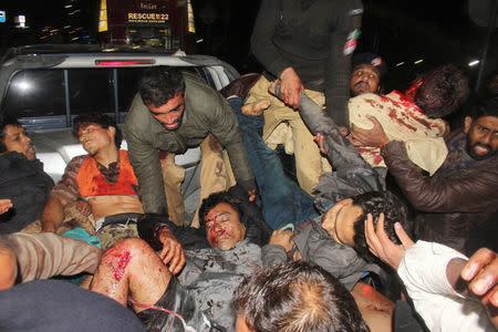 Rescue workers and voluteers load the injured on to the back of a truck to take them to hospital after a blast in Lahore, Pakistan February 13, 2017. REUTERS/Stringer