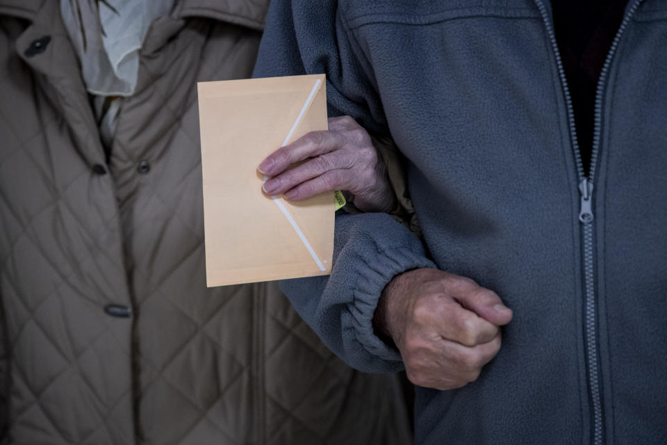 An elderly couple walk into a polling station during the regional election in Madrid, Spain, Tuesday, May 4, 2021. Over 5 million Madrid residents are voting for a new regional assembly in an election that tests the depths of resistance to lockdown measures and the divide between left and right-wing parties. (AP Photo/Bernat Armangue)