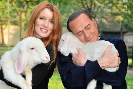 Former prime minister Silvio Berlusconi (R) holds and hugs a lamb as he poses with Michela Vittoria Brambilla, animal right activist and member of parliament for Berlusconi's Forza Italia party, in this undated photo released by the Italian League in Defence of Animals and the Environment. Maurizio Calzari/Lega Italiana Difesa Animali e Ambiente/Handout via Reuters