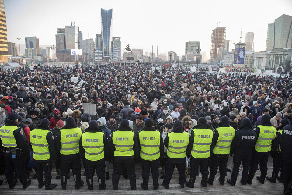 FILE - Police form a barrier as protesters gather at Sukhbaatar Square in Ulaanbaatar, Mongolia on Monday, Dec. 5, 2022, angered by allegations of corruption linked to Mongolia&#39;s coal trade with China, demanding dismissals of officials involved in the scandal. An Associated Press analysis of a dozen countries most indebted to China - including Pakistan, Kenya, Zambia and Mongolia - found payments on the debt are consuming an ever-greater amount of the tax revenue needed to provide basic services. (AP Photo/Alexander Nikolskiy, File)