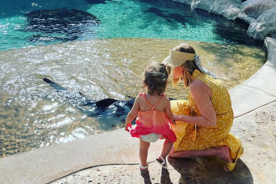 A mom and daughter looking at sharks in the water at a coral nursery in the Bahamas