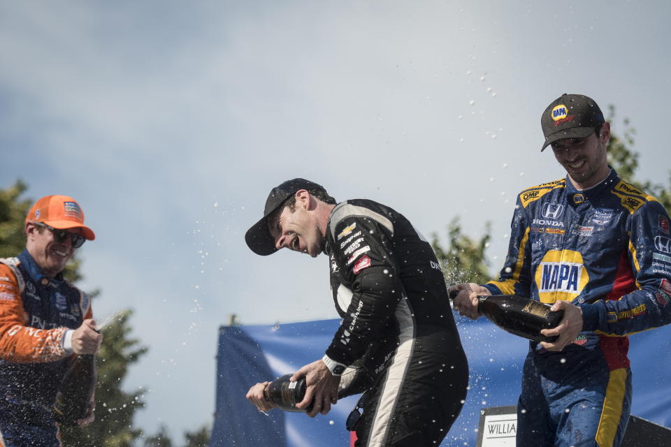 From left to right, second-place finisher Scott Dixon, of New Zealand, first-place finisher Simon Pagenaud, of France, and third-place finisher Alexander Rossi, of the United States, celebrate after the Honda Indy auto race in Toronto, Sunday, July 14, 2019. (Tijana Martin/The Canadian Press via AP)