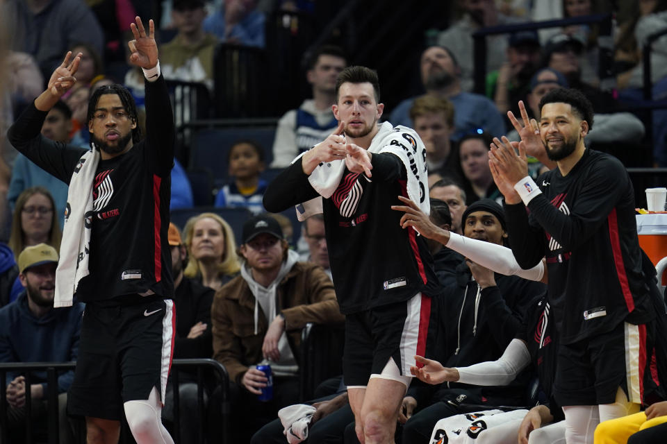 Portland Trail Blazers guard Shaedon Sharpe, left, forward Drew Eubanks, middle and guard Skylar Mays celebrate from the bench during the second half of an NBA basketball game against the Minnesota Timberwolves, Sunday, April 2, 2023, in Minneapolis. (AP Photo/Abbie Parr)