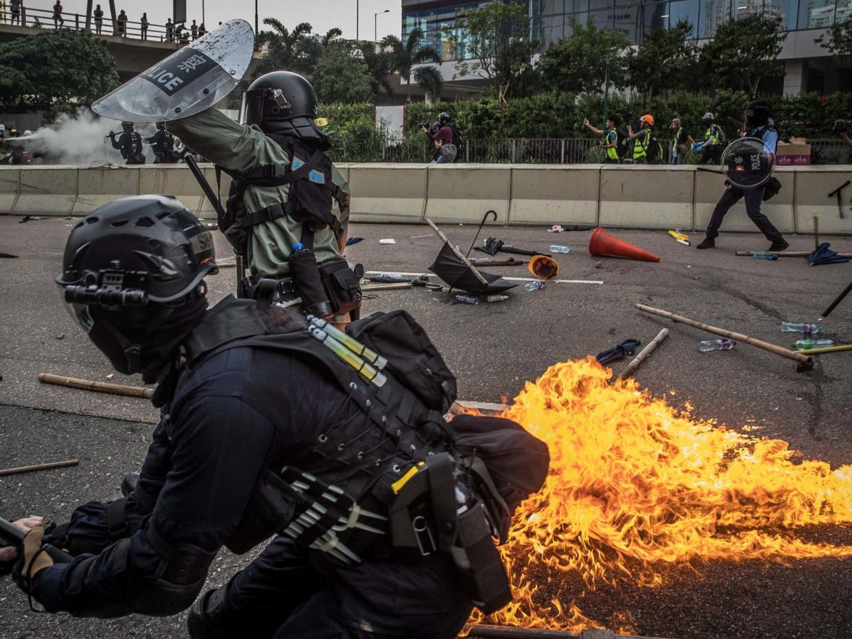 Riot police react after one of the protesters thrown a bottle with flammable liquid during an anti-government march in Kwun Tong, Hong Kong: EPA