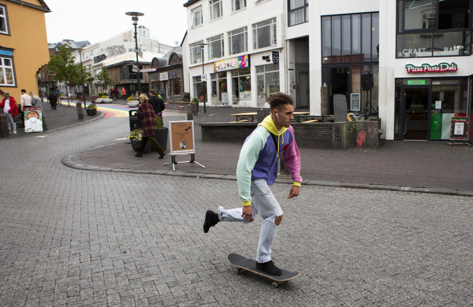 A skateboarder rides down a street in Reykjavik, Iceland Saturday Aug. 1, 2020. In Iceland, a nation so safe that its president runs errands on a bicycle, U.S. Ambassador Jeffery Ross Gunter has left locals aghast with his request to hire armed bodyguards. He's also enraged lawmakers by casually and groundlessly hitching Iceland to President Donald Trump's controversial "China virus” label for the coronavirus. (AP Photo/Árni Torfason)