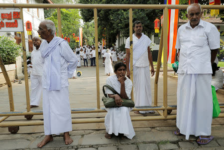 Buddhist worshipers are seen near a police barrier at the Kalaniya Buddhist temple during Vesak Day, commemorating the birth, enlightenment and death of Buddha, in Colombo, Sri Lanka May 18, 2019. REUTERS/Dinuka Liyanawatte