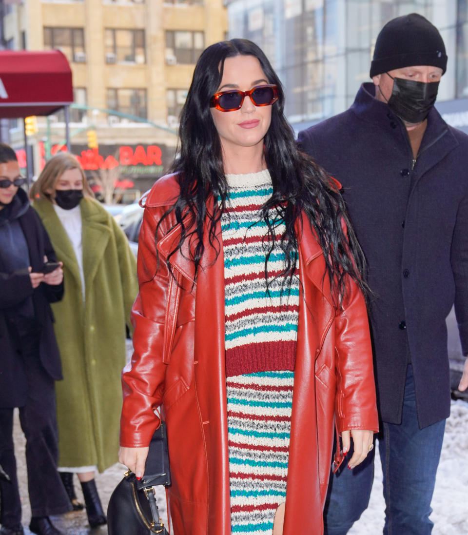 Katy walks down the street while holding her bag