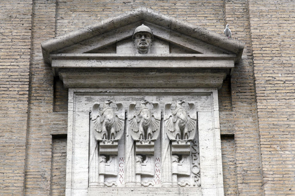 FILE - In this Friday, May 3, 2019. file photo, fasces, the original symbol of Fascism adapted from ancient Rome, showing a bundle of rods tied together around an axe, are seen carved with eagles on the facade of the Madonna dei Monti church, above a plaque commemorating the fallen soldiers of WWI, in downtown Rome. Italy's failure to come to terms with its fascist past is more evident as it marks the 100th anniversary, Friday, Oct. 28, 2022 of the March on Rome that brought totalitarian dictator Benito Mussolini to power as the first postwar government led by a neo-fascist party takes office. (AP Photo/Andrew Medichini, File)