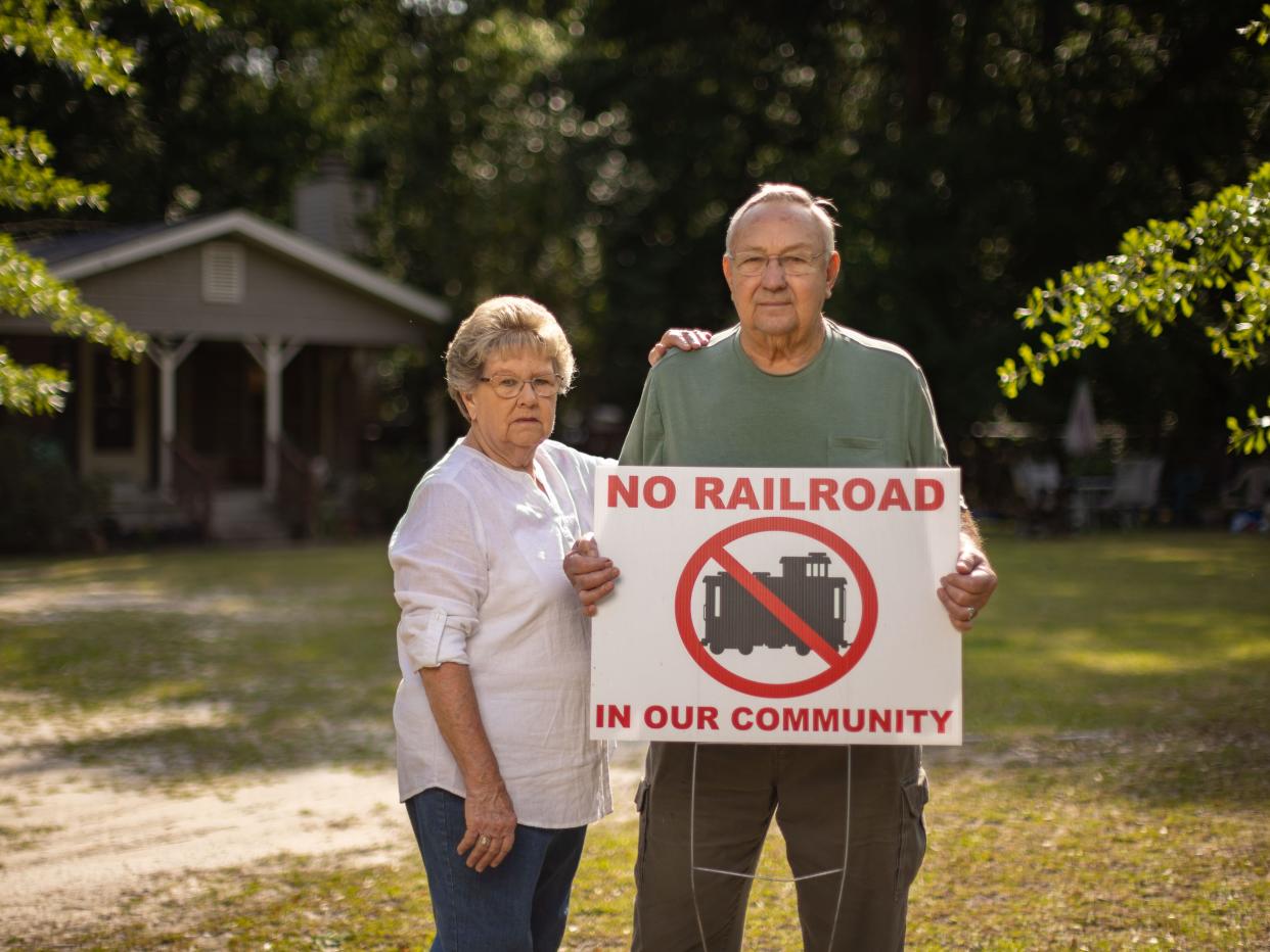 Don and Sally Garrett holding a sign reading, "No railroad in our community."