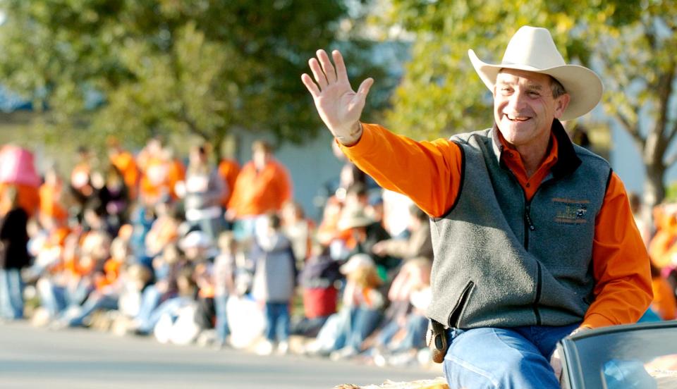 Walt Garrison waves to an Oklahoma State University homecoming crowd in 2006 when he was the grand marshal. Garrison died Wednesday at the age of 79.