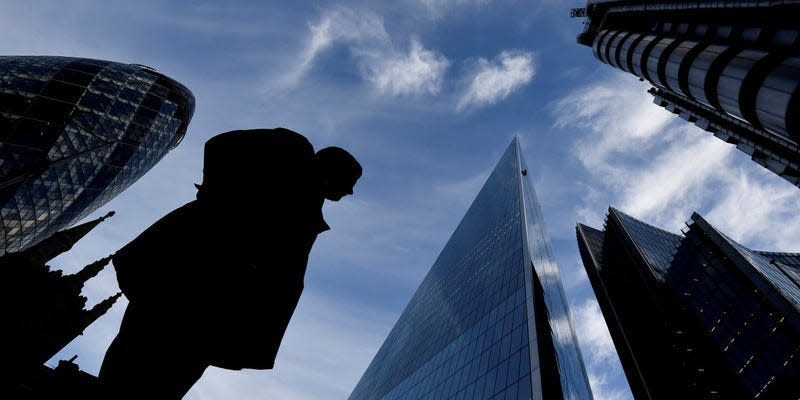 FILE PHOTO: A man walks past The Gherkin and other office buildings in the City of London, Britain November 13, 2018. REUTERS/Toby Melville/File Photo