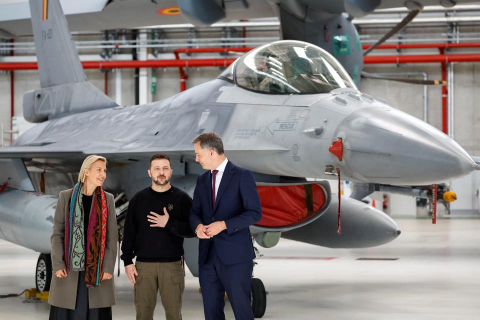 Ukraine's President Volodymyr Zelensky, Belgium's Prime Minister Alexander De Croo and Belgium's Defense Ludivine Dedonder stand near a F-16 (REUTERS)