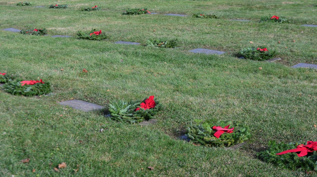 Christmas wreaths placed by volunteers for Wreaths Across America adorn veterans' graves at Alliance City Cemetery on Saturday, Dec. 16, 2023.