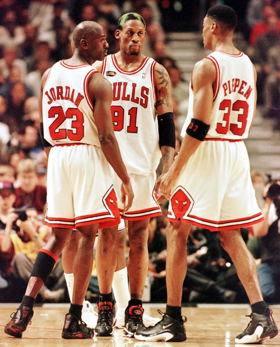 Dennis Rodman of the Chicago Bulls (C) talks to teammates Michael Jordan (L) and Scottie Pippen (L) 10 June during game four of the NBA Finals against the Utah Jazz at the United Center in Chicago, IL. Rodman hit four foul shots down the stretch to lead the Bulls as they beat the Jazz 86-82 to lead the best-of-seven series 3-1. AFP PHOTO/Jeff HAYNES (Photo by JEFF HAYNES / AFP) (Photo credit should read JEFF HAYNES/AFP via Getty Images)