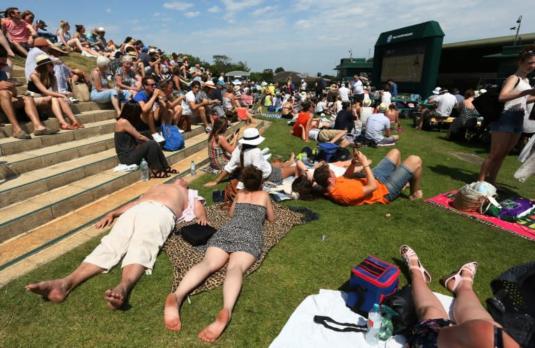 Spectators lie in the sunshine on Murray Mount at The All England Tennis Club on day three of the 2015 Wimbledon Championships in Wimbledon, southwest London, on July 1, 2015