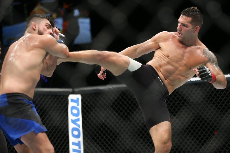 Chris Weidman (R) lands a kick on Kelvin Gastelum (L) on July 22, 2017 in Uniondale, New York. (Getty Images)