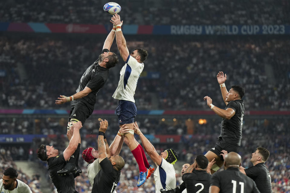 New Zealand's Samuel Whitelock, top left, and France's Charles Ollivon, top right, lunge for the ball during the Rugby World Cup Pool A match between France and New Zealand at the Stade de France in Saint-Denis, north of Paris, Friday, Sept. 8, 2023. France won 27-13. (AP Photo/Lewis Joly)