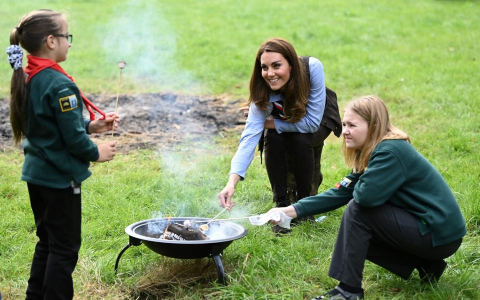 The Duchess of Cambridge toasts marshmallows during her visit to a Scout Group in Northolt - AFP