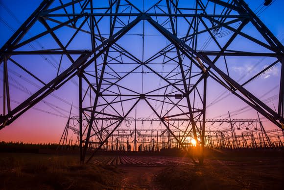 Electric power lines and towers at sunset.