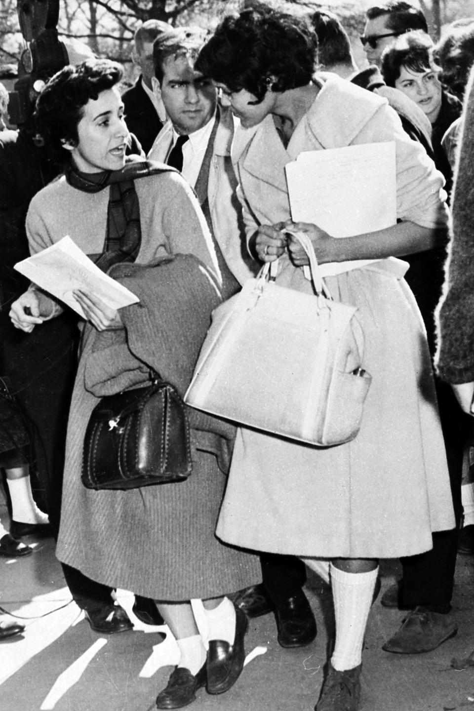 FILE - In this Jan. 11, 1961 photo, Atlanta Associated Press staffer Kathryn Johnson, left, wears bobby socks and a sweater to obtain the only eyewitness story of Charlayne Hunter's first day of class at the University of Georgia, in Athens, Ga. School officials stopped all other reporters at the door but Johnson, who appeared to look like "just another student." Hunter was one of the first two African American students to enroll at the University of Georgia. Johnson, a trailblazing reporter for The Associated Press died Wednesday, Oct. 23, 2019, in Atlanta at the age of 93. (AP Photo)