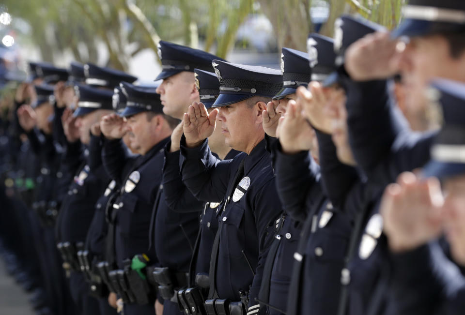 Police officers salute as the body of Ventura County Sheriff's Sgt. Ron Helus is carried into the Calvary Community Church Thursday, Nov. 15, 2018, in Westlake Village, Calif. Helus was fatally shot while responding to a mass shooting at a country music bar in Southern California. (AP Photo/Marcio Jose Sanchez, Pool)