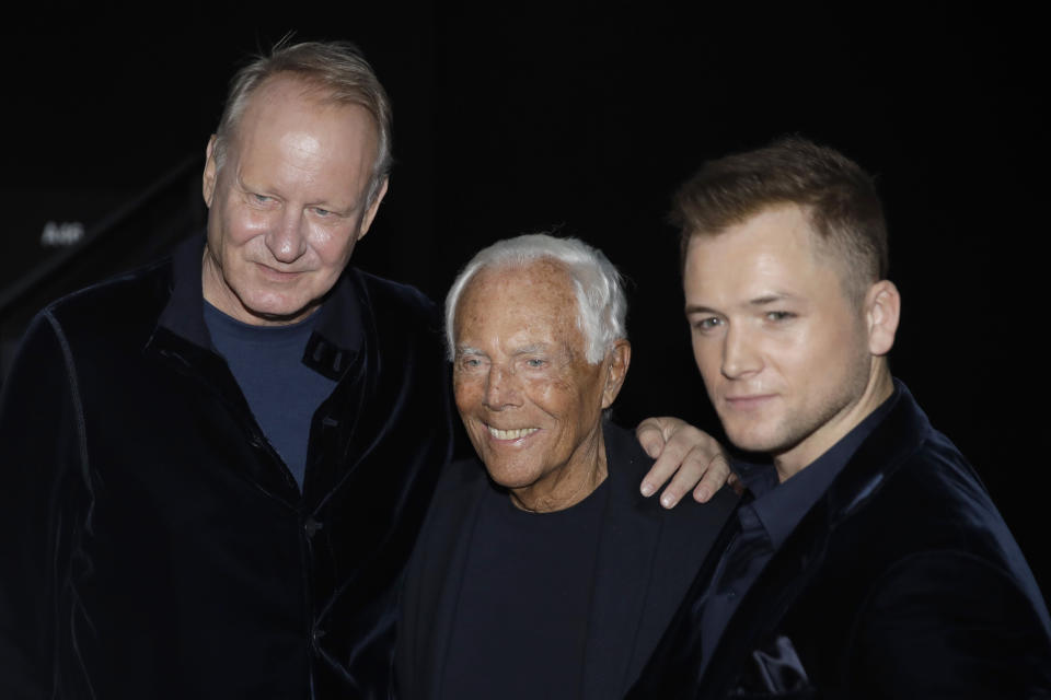 Designer Giorgio Armani, centre, poses with actor Taron Egerton, right, and actor Stellan Skarsgard after the Armani men's Fall-Winter 2020/21 collection, that was presented in Milan, Italy, Monday, Jan. 13, 2020. (AP Photo/Luca Bruno)