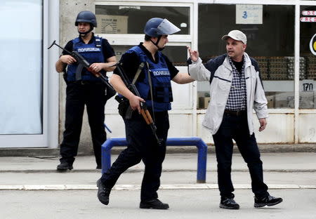 A Macedonian policeman speaks to a man near a police checkpoint in Kumanovo, Macedonia May 9, 2015. REUTERS/Ognen Teofilovski