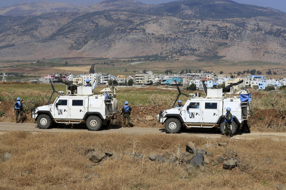 U.N. peacekeepers patrol on the Lebanese side of the Lebanese-Israeli border in the southern village of Wazzani with border village Ghajar in the background, Thursday, July 6, 2023. Israeli forces shelled a southern Lebanese border village on Thursday after several explosions were heard in a disputed area where the borders of Syria, Lebanon and Israel meet. (AP Photo/Mohammad Zaatari)