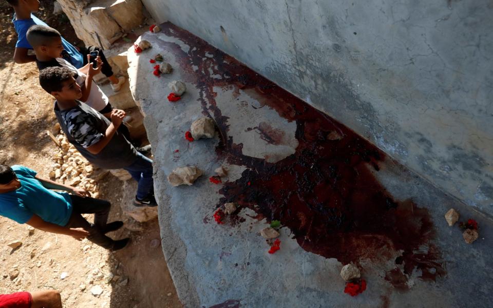 Palestinian kids inspect the scene where Hamas militants were killed by Israeli forces in a gun battle during a raid in Beit Anan - MOHAMAD TOROKMAN /REUTERS