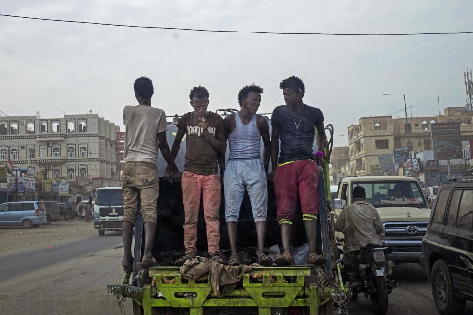 In this July 29, 2019 photo, African migrants make their way to work in Marib, Yemen. In the evenings, thousands of migrants mill around the streets of Marib, one of the main city stopovers on the migrants' route through Yemen. In the mornings, they search for day jobs. They could earn about a dollar a day working on nearby farms. A more prized job is with the city garbage collectors, paying $4 a day. (AP Photo/Nariman El-Mofty)