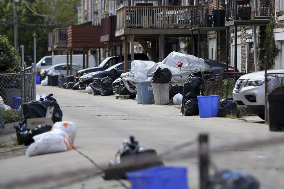 In this photo from May 13, 2020, bags of garbage sit along the street before being picked up in Philadelphia's Ogontz section. Households are generating more trash as people stay home during the coronavirus pandemic. The city's 311 complaint line has received 9,753 calls about trash and recycling as of July 29 compared to 1,873 in February. (Tim Tai/The Philadelphia Inquirer via AP)