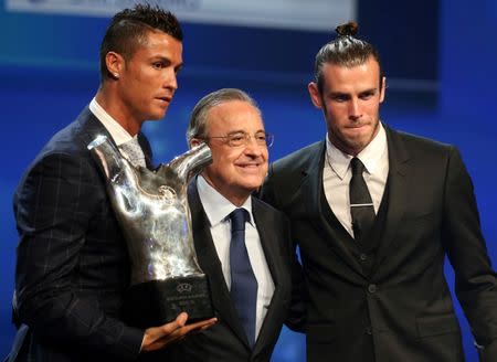 Real Madrid's Cristiano Ronaldo of Portugal (L) poses with Real Madrid President Florentino Perez (C) and Gareth Bale (R) after he received The Best Player UEFA 2015/16 Award during the draw ceremony for the 2016/2017 Champions League Cup soccer competition at Monaco's Grimaldi in Monaco, August 25, 2016. REUTERS/Eric Gaillard