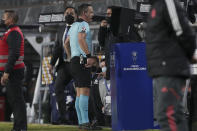 Referee Patricio Loustau of Argentina checks the VAR during a Copa Sudamericana soccer match between Chile's Colo Colo and Brazil's Internacional in Santiago, Chile, Tuesday, June 28, 2022. (AP Photo/Luis Hidalgo)