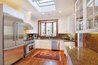 <p>The large kitchen features white, Shaker-style cabinets and granite countertops. (Zillow) </p>