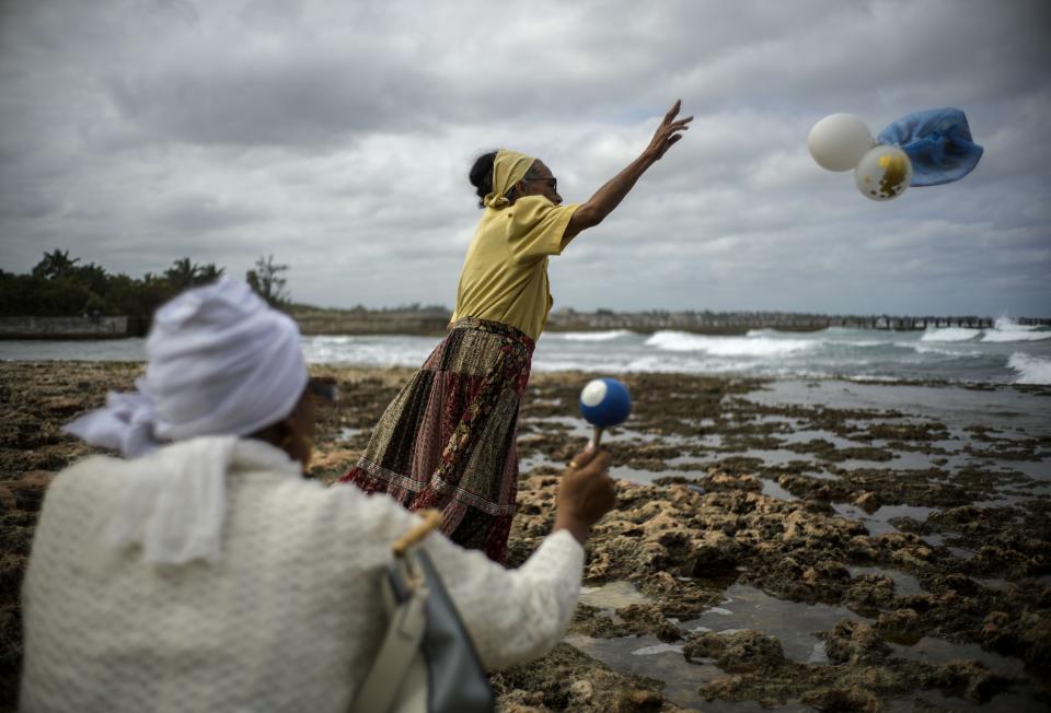 Gloria Esperanza Reyes hace su ofrecimiento mensual de flores y jarabe de caña de azúcar a Yemaya, la diosa Yoruba del mar, el miércoles 14 de febrero de 2024, en La Habana, Cuba. Ella también es venerada como Nuestra Señora de Regla, una Virgen María negra en la iglesia católica ubicada al otro lado de la Bahía de La Habana. (AP Foto/Ramón Espinosa)