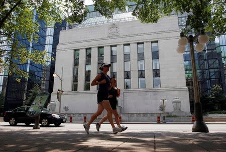 FILE PHOTO: Joggers run past the Bank of Canada building in Ottawa July 17, 2012. REUTERS/Chris Wattie/File Photo