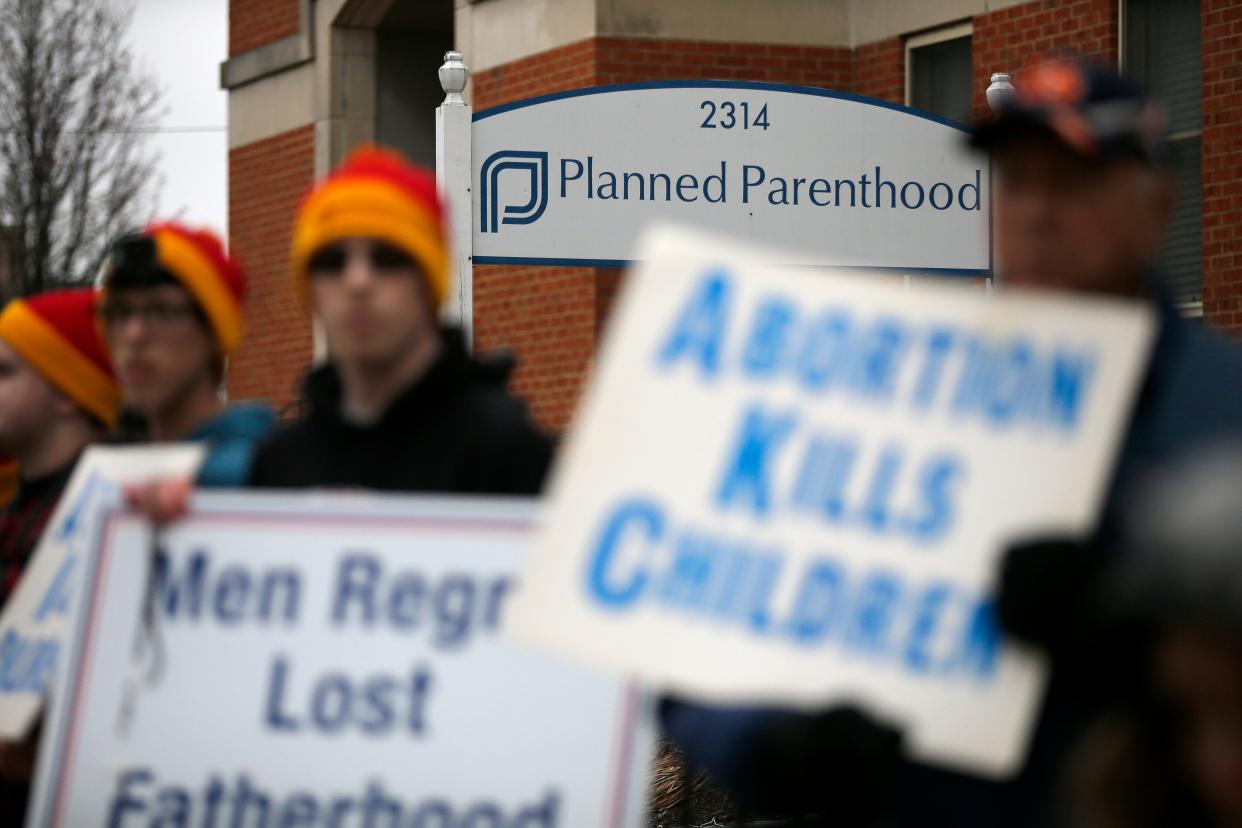 Demonstrators gather to pray and protest during a local gathering in support of the national March for Life event in front of the Planned Parenthood office in the Mt. Auburn neighborhood of Cincinnati on Friday, Jan. 18, 2019.