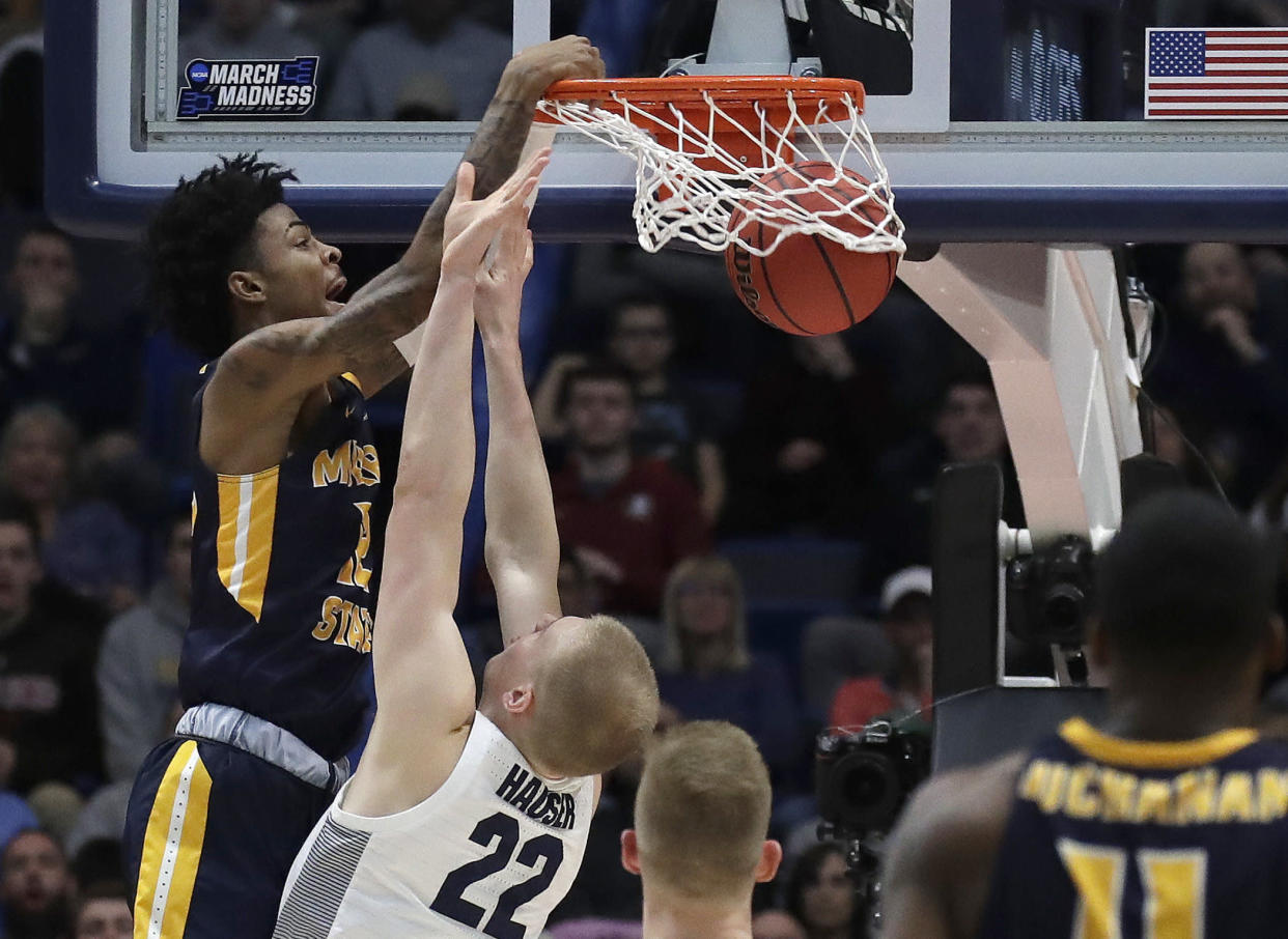 Murray State's Ja Morant, left, dunks over Marquette's Joey Hauser (22) during the second half of a first round men's college basketball game in the NCAA Tournament, Thursday, March 21, 2019, in Hartford, Conn. (AP Photo/Elise Amendola)