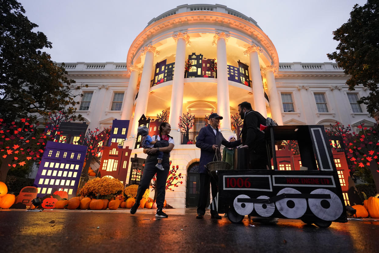 President Joe Biden and first lady Jill Biden give treats to trick-or-treaters on the South Lawn of the White House, on Halloween, Monday, Oct. 31, 2022, in Washington. (AP Photo/Alex Brandon)